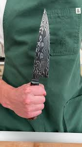 An image of someone improperly holding a chef knife. What's the best way to hold a chef knife? Still unclear.
