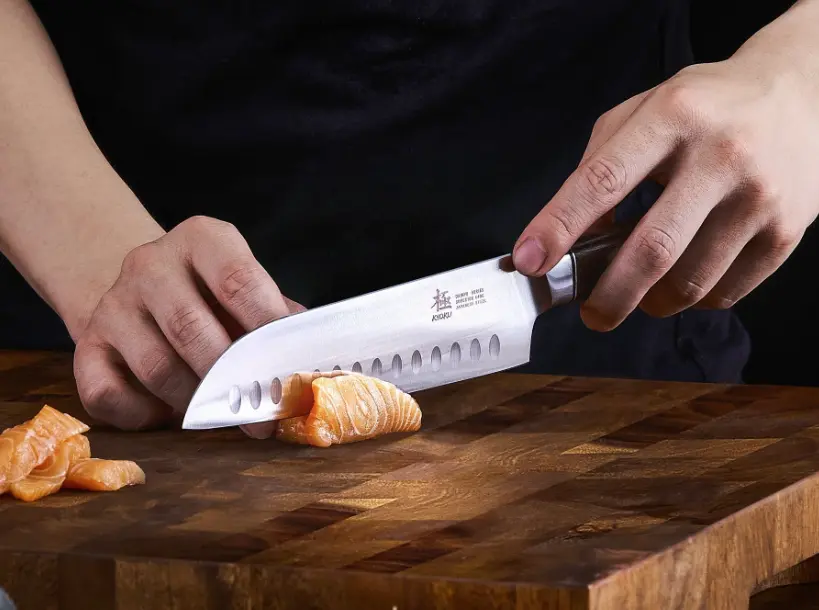 an image of a santoku knife being used with proper grip on an end grain cutting board. The best way to hold a knife.