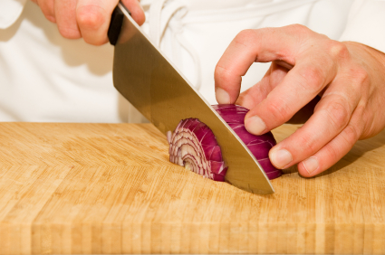 An image of someone using the claw grip. The safest chef knife grip - precise and efficient.
